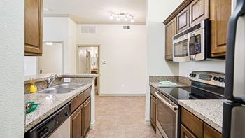 A kitchen with a black stove top oven and a black microwave above the stove.